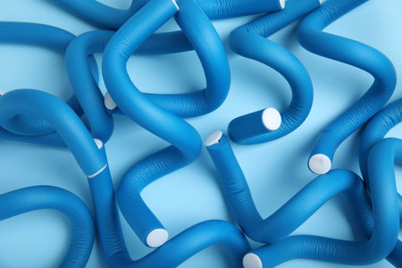 Curling rods on turquoise background, top view. hair styling toolの写真素材