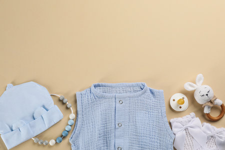 Flat lay composition with baby clothes and accessories beige background, space for textの写真素材