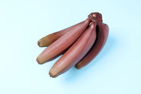 Tasty red baby bananas on light blue background, top viewの写真素材