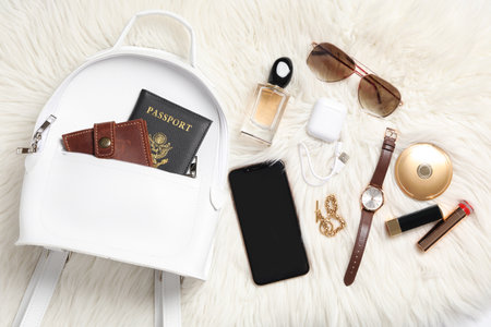Stylish urban backpack and different items on white faux fur, flat layの写真素材