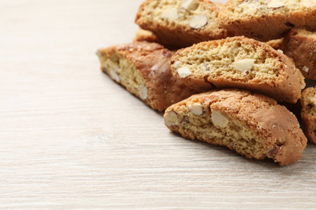 Traditional Italian almond biscuits (Cantucci) on white wooden table, closeup. Space for textの写真素材
