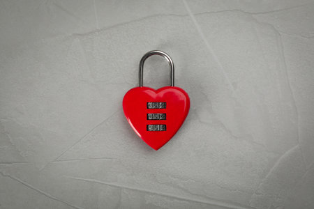 Red heart shaped combination lock on light gray table, top viewの写真素材
