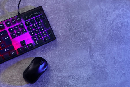 Modern RGB keyboard and mouse on gray table, flat lay. Space for textの写真素材
