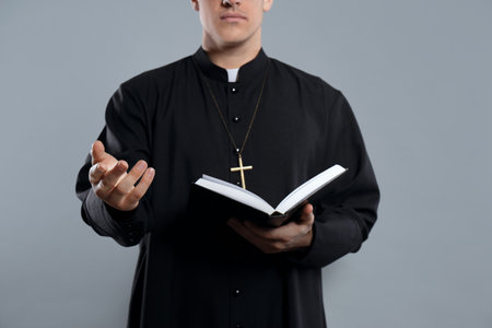 Priest with Bible on gray background, closeupの写真素材