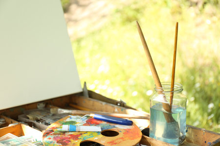 Easel with canvas and painting equipment outdoors, closeupの写真素材