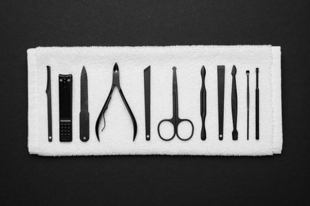 Towel with set of manicure tools on black background, top viewの写真素材