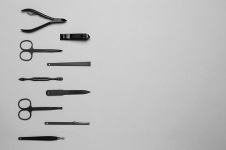 Set of manicure tools on gray background, flat lay. Space for textの写真素材