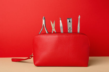 Manicure set in red bag on beige tableの写真素材