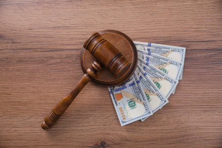 Judge's gavel and dollar bills on wooden table, flat layの写真素材