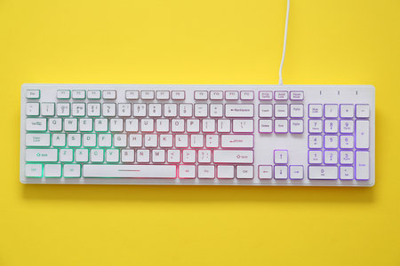 Modern RGB keyboard on yellow background, top viewの写真素材