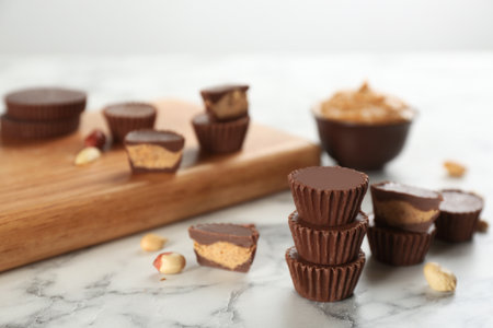 Delicious peanut butter cups on white marble table, space for textの写真素材