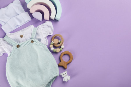 Flat lay composition with baby clothes and accessories on violet background, space for textの写真素材