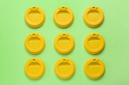 Plastic caps for disposable cups on green background, flat layの写真素材