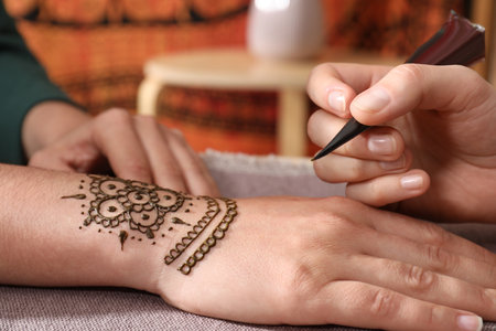 Master making henna tattoo on hand, closeup. traditional mehndiの写真素材