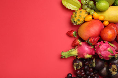 Many different delicious exotic fruits on red background, flat lay. Space for textの写真素材