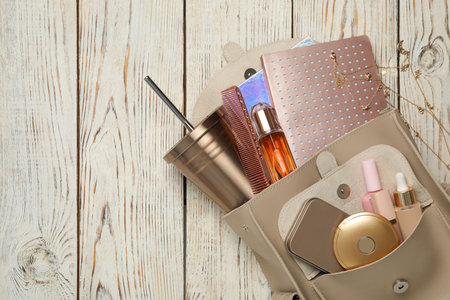 Stylish urban backpack with different items on white wooden background, flat lay. Space for textの写真素材