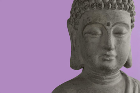 Beautiful stone Buddha sculpture on violet background, closeup. Space for textの写真素材