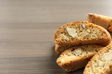 Traditional Italian almond biscuits (Cantucci) on wooden table, closeup. Space for textの写真素材