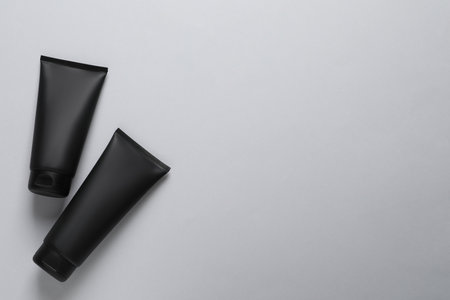 Tube of men's facial cream on light gray background, flat lay. Space for textの写真素材