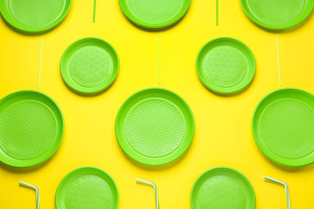 Plastic dishware on yellow background, flat layの写真素材