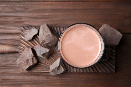 Fresh yummy chocolate milk on wooden table, top viewの写真素材