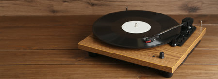 Turntable with vinyl record on wooden background. Space for textの写真素材