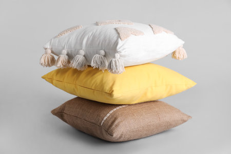 Stack of stylish soft pillows on gray backgroundの写真素材