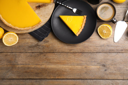 Delicious homemade lemon pie, fruits and coffee on wooden table, flat lay. Space for textの写真素材