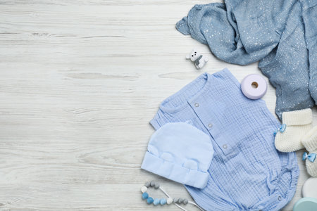 Flat lay composition with baby clothes and accessories on white wooden table. Space for textの写真素材