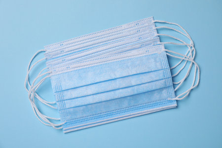 Protective masks on light blue background, flat lay. safety equipment