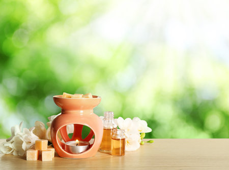 Composition with aroma lamp on wooden table outdoors, space for text. bokeh effectの写真素材