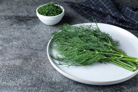 Fresh dill on gray table, space for text