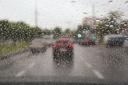 Blurred view of road through wet car window. rainy weatherの写真素材