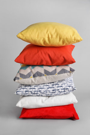 Stack of stylish soft pillows on gray backgroundの写真素材