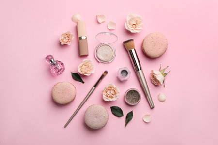 Flat lay composition with makeup products, roses and macarons on pink backgroundの写真素材