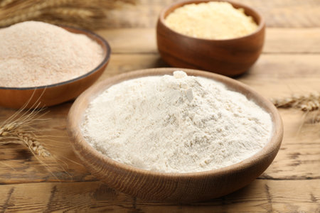 Wheat flour in bowl on wooden tableの写真素材