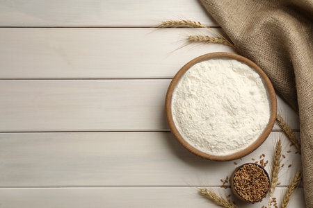 Flat lay composition with wheat flour on white wooden table. Space for textの写真素材