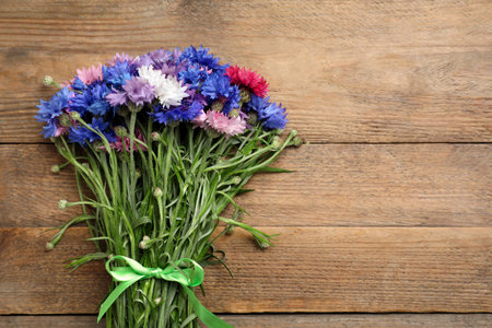 Bouquet of beautiful cornflowers on wooden table, top view. Space for textの写真素材