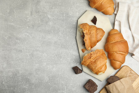 Flat lay composition with tasty croissants and chocolate on light gray table. Space for textの写真素材