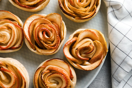 Freshly baked apple roses on gray table, flat lay. beautiful dessertの写真素材