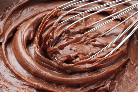 Whipping chocolate cream with balloon whisk, closeup viewの写真素材