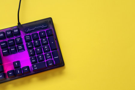 Modern RGB keyboard on yellow background, top view. Space for textの写真素材
