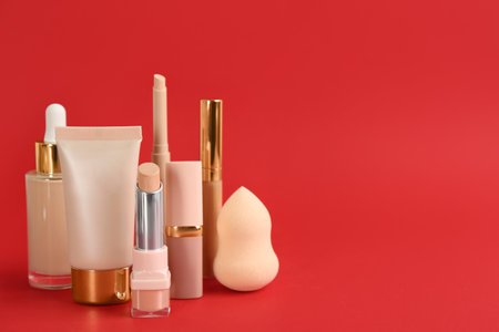 Foundation makeup products on red background, space for text. decorative cosmeticsの写真素材