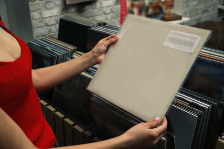 Woman with vinyl record in store, closeupの写真素材