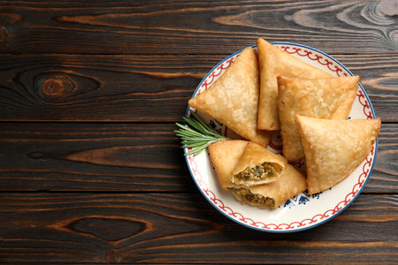 Fresh delicious crispy samosas served on wooden table, top view. Space for textの写真素材