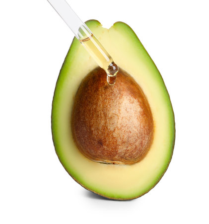 Dripping essential oil onto cut avocado on white backgroundの写真素材