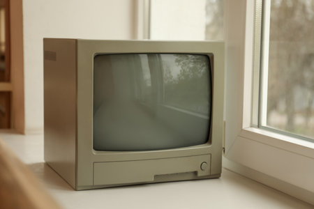 Old tv set on white windowsill indoorsの写真素材