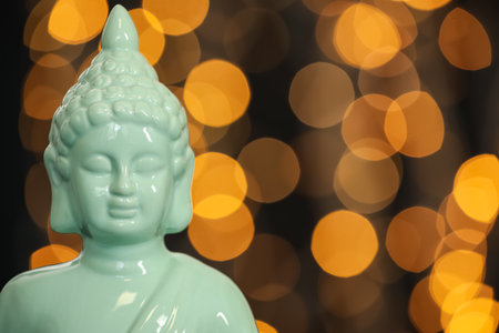 Buddha statue against blurred lights, closeup. Space for textの写真素材