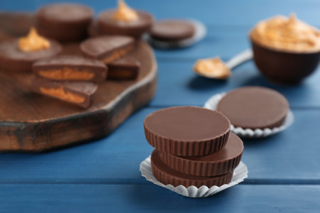 Delicious peanut butter cups on blue wooden table, space for textの写真素材
