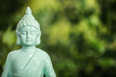 Buddha statue against blurred green background, closeup. Space for textの写真素材
